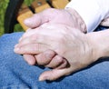 Palms of wrinkled hands of an elderly holding of man female hand Royalty Free Stock Photo