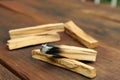 Palo Santo stick smoldering on wooden table, closeup Royalty Free Stock Photo