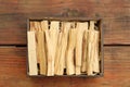 Palo Santo sticks in box on wooden table, top view