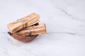 Palo Santo tree sticks inside coconut shell on light marble background - holy incense tree from Latin America. Meditation, mental