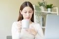 Palpitation, suffer asian young woman holding mug, drinking strong a cup of coffee, touching her chest after drink caffeine, tea