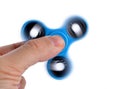 Palying with a blue Fidget Spinner. Royalty Free Stock Photo