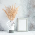 Pampas grass in ceramic vase and empty photo frame against wall. Minimalistic Scandinavian style Royalty Free Stock Photo