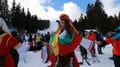 People dressed with traditional Bulgarian clothes skiing with the Bulgarian national flag. Royalty Free Stock Photo
