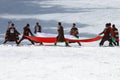 People dressed with traditional Bulgarian clothes skiing with the Bulgarian national flag. Royalty Free Stock Photo