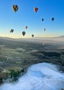 Pamukkale, Denizli, Turkiye - July 7, 2022 : Top view, balloon tourism activities in the sky floating above Cotton Castle or white