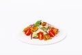 Pan-Asian salad, vegetables with fried chicken in batter. On a white plate on a white background Royalty Free Stock Photo