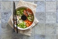 Pan Asian trendy Homemade Poke Bowl with Salmon, Rice, edamame, fresh vegetables and soy sauce, served with chopsticks on ceramic