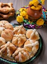 Pan de Muerto. Traditional Mexican Bread of the Dead over wooden table with typical mexican decoration. AI generated