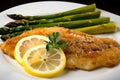 Pan-fried catfish fillets with a buttery lemon sauce and a side of garlicky roasted asparagus Royalty Free Stock Photo