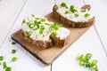 Pan of fried eggs with tomatoes, cheese, spring onion, herbs on a white table. Bread with spread. White wooden table. Concept of f Royalty Free Stock Photo