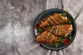 Pan Fried Rose fish with herbs on a round plate on a dark background