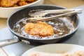 Pan full of oil is used for frying breaded meat while making wiener schnitzels