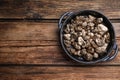 Pan of gold nuggets on wooden table, top view. Space for text Royalty Free Stock Photo