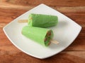Pan kulfi served in white plate over a rustic wooden background, selective focus