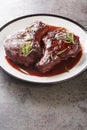 Pan Seared Pork Chops with red wine sauce and herbs closeup on the plate. Vertical Royalty Free Stock Photo