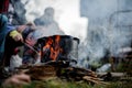 Pan standing on the campfire on the background of the group of people Royalty Free Stock Photo