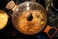 Pan on the stove with condensation on the glass lid, close-up