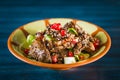 Pan of traditional Japanese yakitori dish - fried checken hearts served with sesame, teriyaki sauce and fresh vegetables at wooden Royalty Free Stock Photo