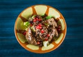 Pan of traditional Japanese yakitori dish - fried checken hearts served with sesame, teriyaki sauce and fresh vegetables at wooden Royalty Free Stock Photo