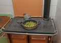 Pan with zucchini baked in cast iron stove with fire lit