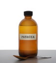 Panacea, magic potion. Old brown glass medicine bottle with spoon, label. Pharmaceutical concept or ironic metaphor Royalty Free Stock Photo
