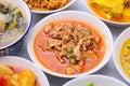 Panaeng Curry with Pork.Sliced M in red curry paste and coconut milk in a bowl on the set of group plates Thai food. Top view.