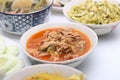 Panaeng Curry with Pork.Sliced M in red curry paste and coconut milk in a bowl on the set of group plates Thai food. Top view.