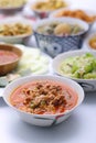 Panaeng Curry with Pork.Sliced M in red curry paste and coconut milk in a bowl on the set of group plates Thai food. Top view. Royalty Free Stock Photo