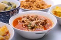 Panaeng Curry with Pork.Sliced M in red curry paste and coconut milk in a bowl on the set of group plates Thai food. Top view.