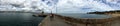 Panaromic view of deck going to pier with sea, & cloudy sky meeting in horizon