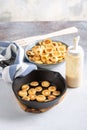 Pancake cereal. Heap of mini pancakes in cast iron pan on concrete background. Trendy food. Copy space