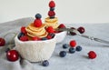 Pancake cereal, mini pancakes in a bowl with blueberries, raspberries, cherries. Healthy nutrition. Culinary trend. Homemade food Royalty Free Stock Photo