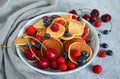 Pancake cereal, mini pancakes in a plate with blueberries, raspberries, cherries. Healthy nutrition. Culinary trend. Homemade food Royalty Free Stock Photo