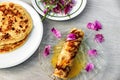 Pancake Crepe Suzette on glass plate with peony petal on gray table Royalty Free Stock Photo