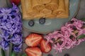 pancake plate surrounded by hyacinth flowers, fresh strawberries and blueberries