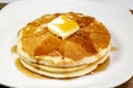 Pancake with a square of butter and syrup on a kitchen table waiting to be eaten Royalty Free Stock Photo