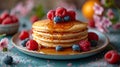 Pancake stacks with maple syrup and raspberry with blueberry for a sweet breakfast