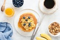 Pancakes with banana, blueberry and cup of coffee, tasty breakfast