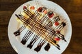 Pancakes with bananas and chocolate caramel sauce,Topping with whip cream and strawberry on table Royalty Free Stock Photo