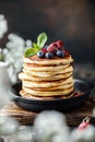 Pancakes with berries and maple syrup. Sweet homemade stack of pancakes