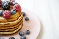 Pancakes with berries on a pink plate, side view. Healthy summer breakfast. Closeup. Royalty Free Stock Photo