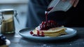 Pancakes with berry compote being poured, dark setting,. AI Generated Royalty Free Stock Photo