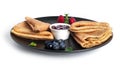 Pancakes with berry jam isolated on a white background. Pancakes with strawberries and blueberries on black plate.