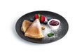 Pancakes with berry jam isolated on a white background. Pancakes with strawberries and blueberries on black plate.