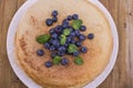 Pancakes with blueberries and honey on a plate, on wooden roofing. Traditional pastries for the Russian festival of Royalty Free Stock Photo