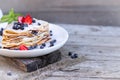 Pancakes with blueberries and mint leaf on top. A bunch of big homemade pancakes with forest fruits. A pile of flat thin