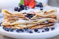 Pancakes with blueberries and mint leaf on top. A bunch of big homemade pancakes with forest fruits. A pile of flat thin