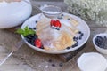 Pancakes with blueberries and mint leaf on top. A bunch of big homemade pancakes with forest fruits. A pile of flat thin