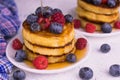 Pancakes with blueberries, raspberries and maple syrup on a white plate. Close-up. Royalty Free Stock Photo